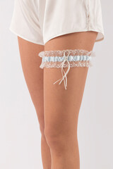 A detailed, elegant close-up of a bridal wedding garter set against a clean, white background.
