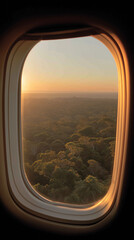 Window Seat View: A breathtaking, aerial perspective through an airplane window, offering a stunning vista of a serene, tree-covered landscape at sunrise, enveloped in a soft, golden glow.