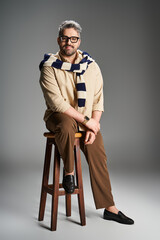 Stylish man in elegant outfit poses confidently in studio setting with modern flair