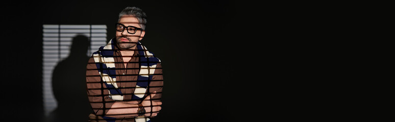 Handsome man exudes charm and style in elegant attire against a minimalist backdrop