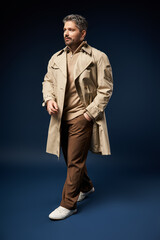 Handsome man with bristle showcases a chic outfit in a modern studio setting