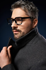 Stylish man with glasses poses elegantly in a fashionable studio setting