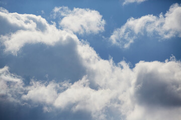 Bright cumulus clouds against a vibrant blue sky create an image of purity, lightness, and tranquility.