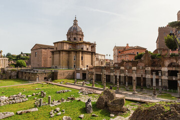 Obraz premium Roman Forum with church of Santi Luca e Martina in Rome, Italy, surrounded by columns, ruins and green lawns