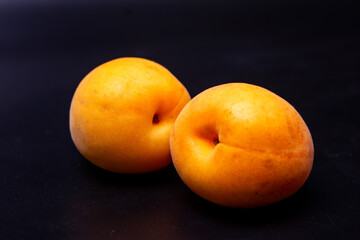Two apricots on a black background