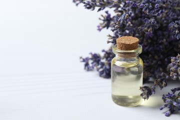 Herbal oil and lavender flowers on white background - beauty treatment. Lavender essential oil still life