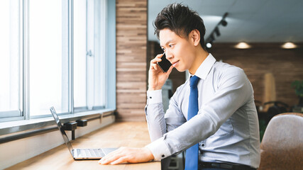 スマートフォンで通話をする笑顔の男性ビジネスマン