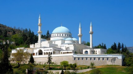 A stunning Ottoman mosque complex features a blue dome, white walls, and tall minarets, set against a clear sky and surrounded by lush greenery