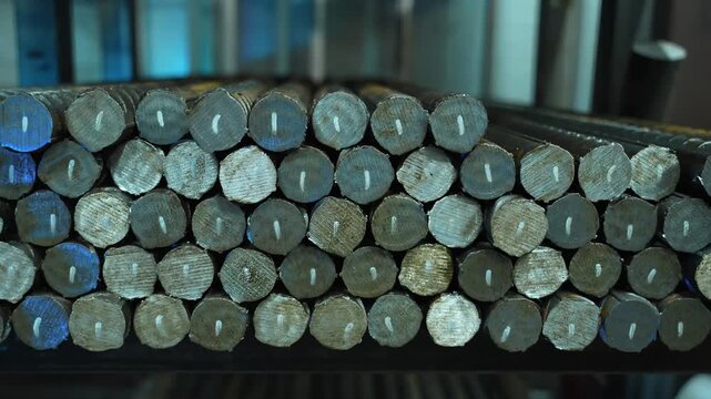 Thick metal reinforcement bars with neatly cut ends stacked in warehouse