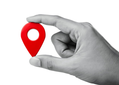 A hand holds a red location pin, isolated on transparent background