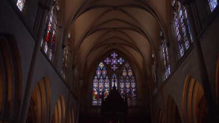 Warm candlelight creates a serene atmosphere, illuminating the colorful stained glass window of a gothic church, showcasing its intricate details and spiritual significance - Powered by Adobe