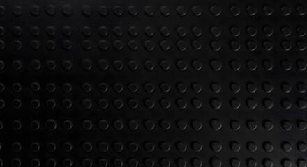 Abstract black texture with raised circular bumps creating a modern, tactile pattern, offering a sense of industrial design and geometrical repetition, and a sleek, monochrome aesthetic.