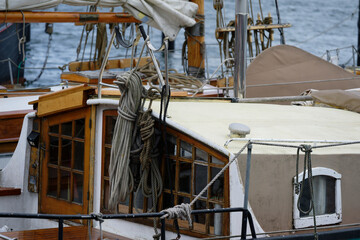Old yacht with coiled marine ropes wooden door and window near the shore