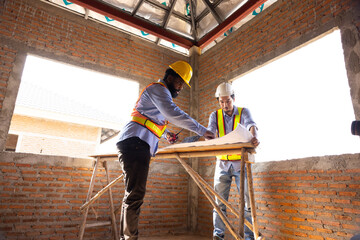 Fototapeta premium blue print interior design : Architects and contractor working together inside building under construction site. home renovation process. Engineering in safety harthat helmet. Engineering team