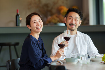 モダンなリビングダイニングで赤ワインを飲む夫婦