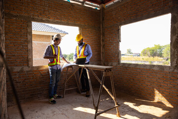 Fototapeta premium Professional Engineer team Working on Personal Computer at Residential Building Construction site. African American Architect and contractor worker planning and architecture. Professional teamwork