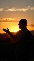 Contemplative silhouette of a man presenting against a brilliant sunset backdrop