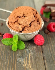 Chocolate ice cream in a strainer with raspberries and mint