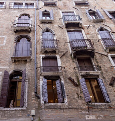 facade of an old building with covered windows in venice italy