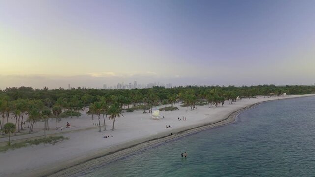 Aerial sunset view of Brandon Park and South Beach, Miami, with people on the beach and downtown Miami skyline in the background