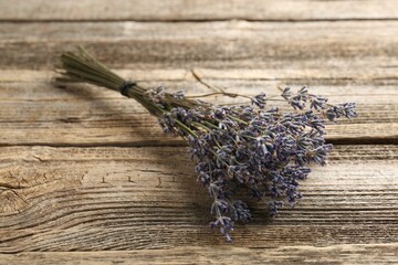 Bunch of aromatic lavender flowers on wooden table, closeup