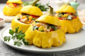 Tasty stuffed pattypan squashes on grey textured table, closeup