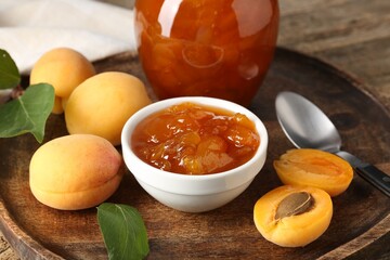 Tasty apricot jam and fresh fruits on wooden table, closeup