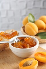 Tasty apricot jam and fresh fruits on table, closeup