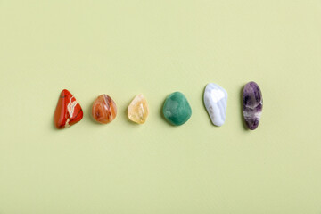 Chakra gemstones on light green background, flat lay