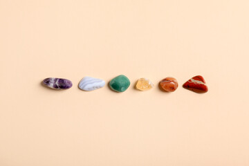 Chakra gemstones on beige background, flat lay