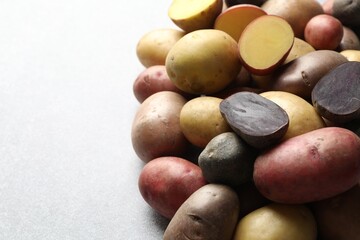 Different types of potatoes on grey table, closeup. Space for text