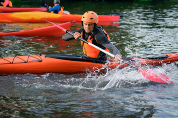Fototapeta premium Kayaker performs underwater flip exercises, practicing rescue safety skills training session on the calm waters of a picturesque lake, skillfully maneuvering their boats