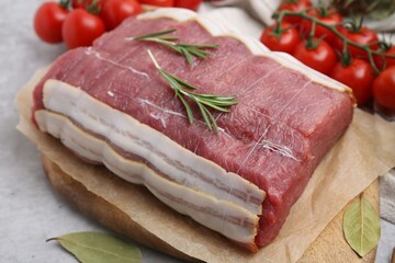 Piece of raw beef meat, tomatoes and spices on grey table, closeup