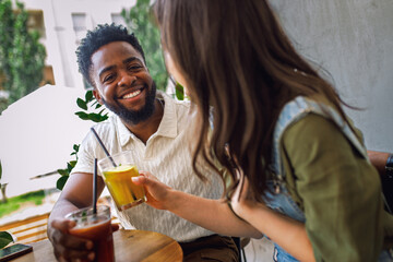 Happy young couple relaxing and talking while sitting together in cozy modern cafe.