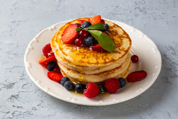 Healthy summer breakfast, homemade classic american pancakes with fresh fruit and honey