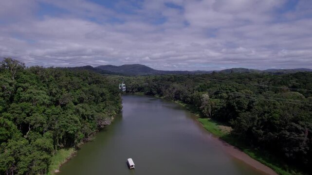 Aerial view of Barron River in Queensland with Skyrail rainforest cablecar above, lush green forest