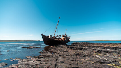 old wrecked sunken ship on the rocky shore of the Arctic Ocean