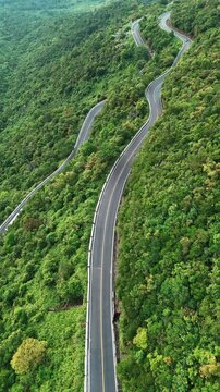 aerial view of HaiVan pass mountain road in Vietnam, scenic beauty and rugged adventure, drone perspective of winding mountain highway, wild terrain and travel thrill, 4k vertical video