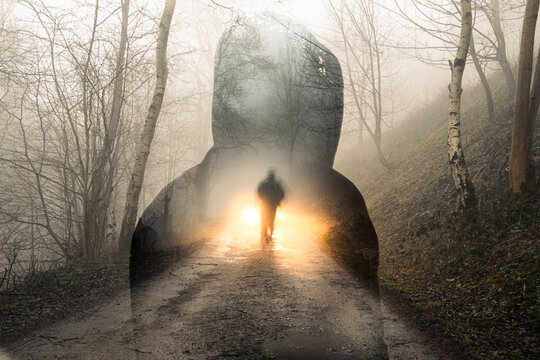 A double exposure of a spooky hooded figure, with a blurred ghost like figure silhouetted by headlights in a forest - Powered by Adobe