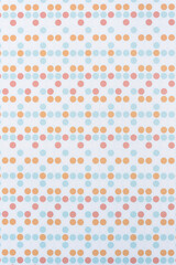 scrapbooking paper with faint blue, orange, and red dots