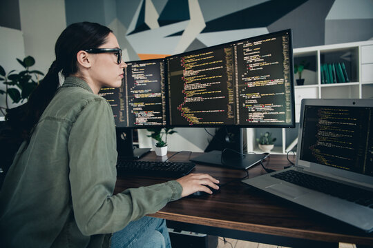 Young programmer working on computer code development, focusing on programs and problem solving in a modern workspace