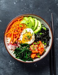 Colorful bowl of rice, fish, vegetables, and egg