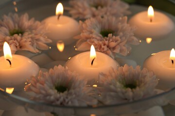 Burning candles and flowers in bowl of water as background, closeup