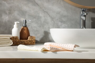 Clean waffle towels and cosmetic products on counter in bathroom, closeup