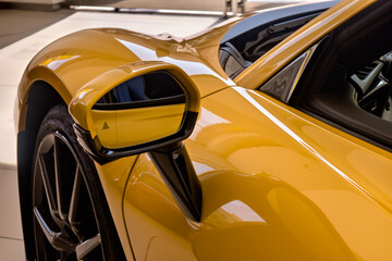 Close up shot of yellow car's side mirror.