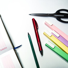 Flat lay of school supplies, pastel highlighters, scissors, notebooks, and pencil, perfect for academic-themed visuals.
