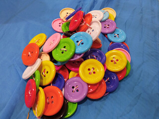 Closeup group of colorful buttons on paper blue texture background for graphic design. illustration fashion style, sewing accessories.