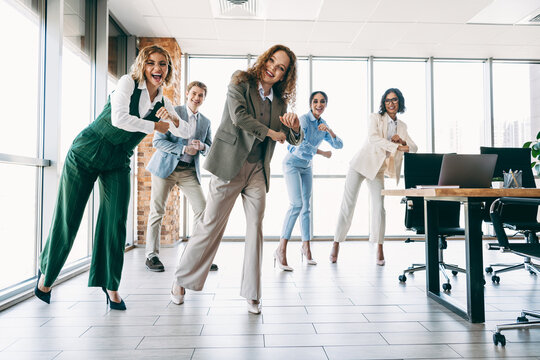 Dynamic group of business professionals enjoying a motivational team-building session in a modern corporate office space - Powered by Adobe