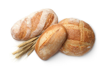 Different types of bread and wheat spikes isolated on white, top view