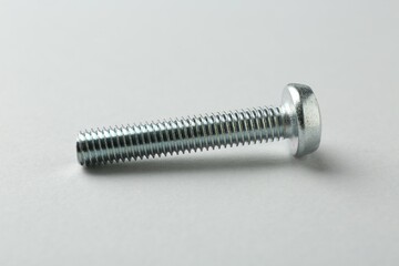 One metal bolt on light grey background, closeup. Hardware tool